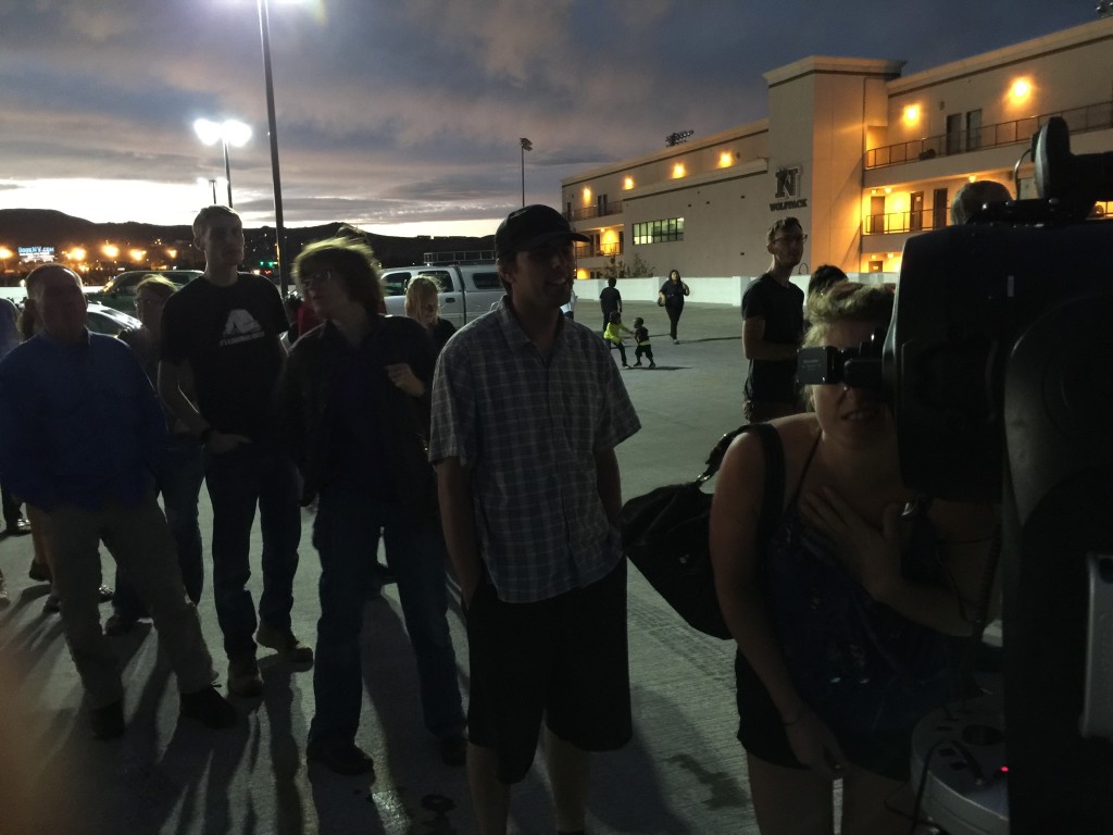 Hopeful eclipse watchers line up to view tower on top of mountain peak since eclipse is obscured by clouds.